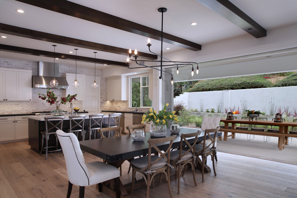Inspiration for a transitional dining room in Orange County with white walls, light hardwood floors and no fireplace.