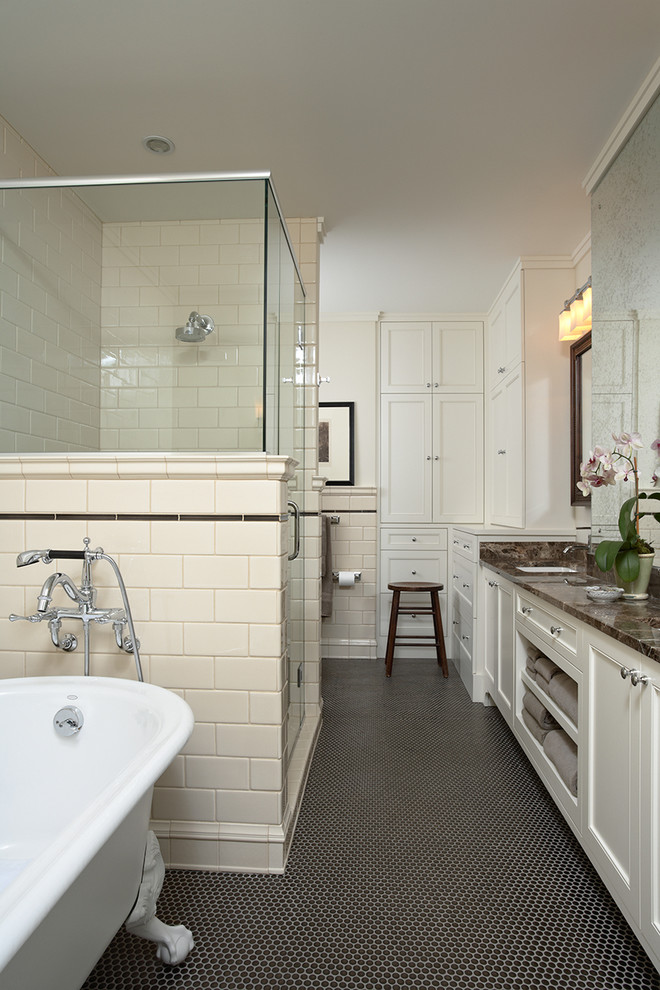 This is an example of a traditional bathroom in Minneapolis with an undermount sink, a claw-foot tub, a corner shower, recessed-panel cabinets, white cabinets, beige tile, subway tile, black floor and brown benchtops.