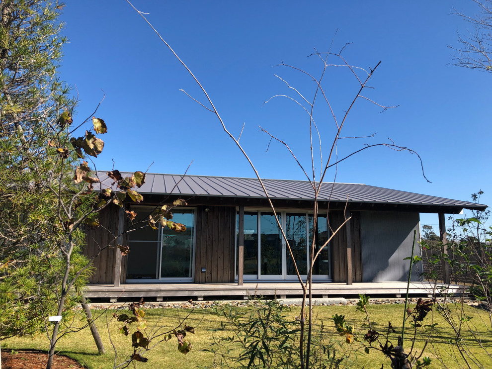 Diseño de fachada de casa gris de una planta con tejado de metal