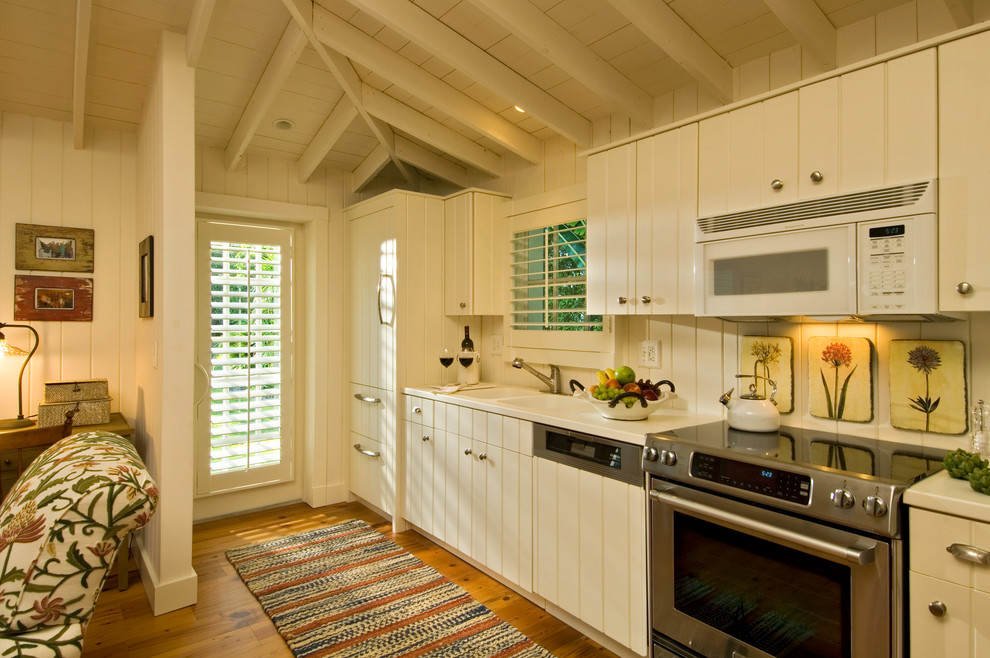Tropical open plan kitchen in New York with a double-bowl sink and beige cabinets.