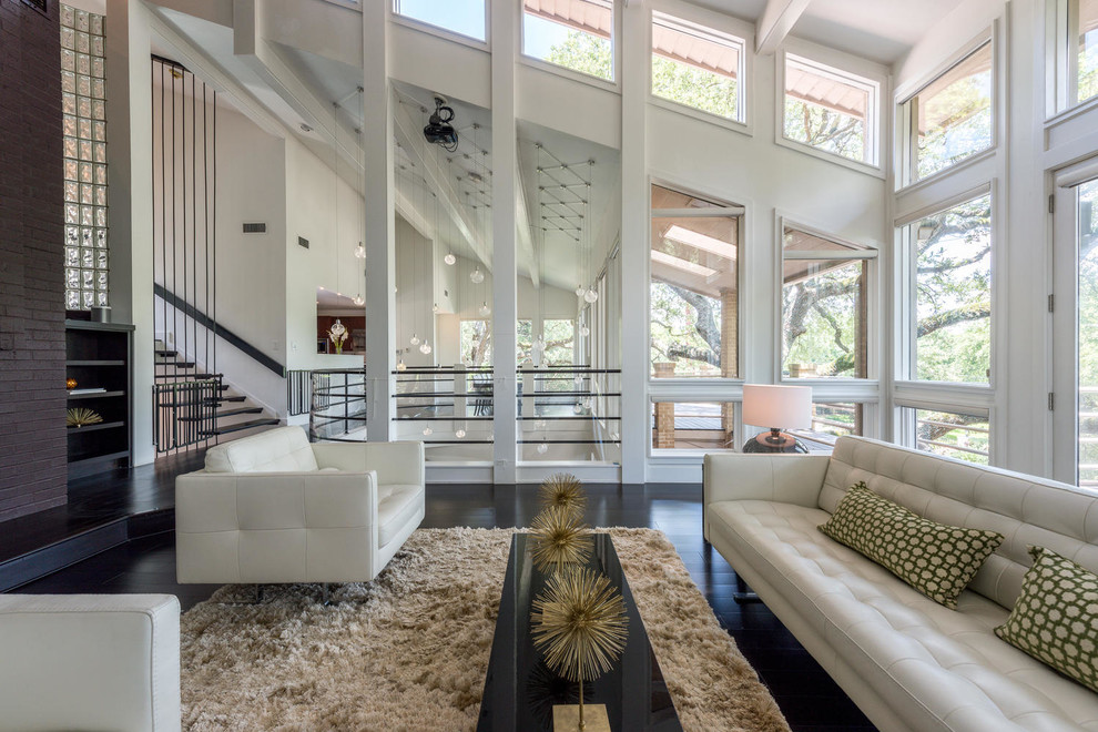 Inspiration for a contemporary loft-style dark wood floor living room remodel in Austin with white walls, a standard fireplace and a brick fireplace