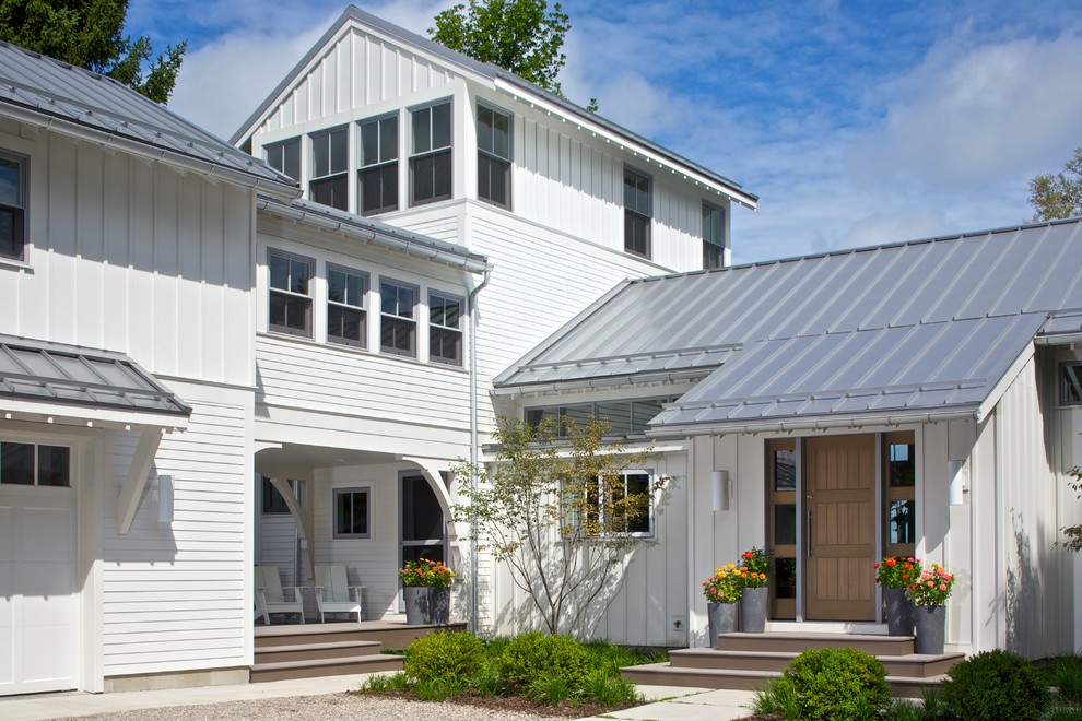 Photo of a traditional white exterior in Grand Rapids with a metal roof.