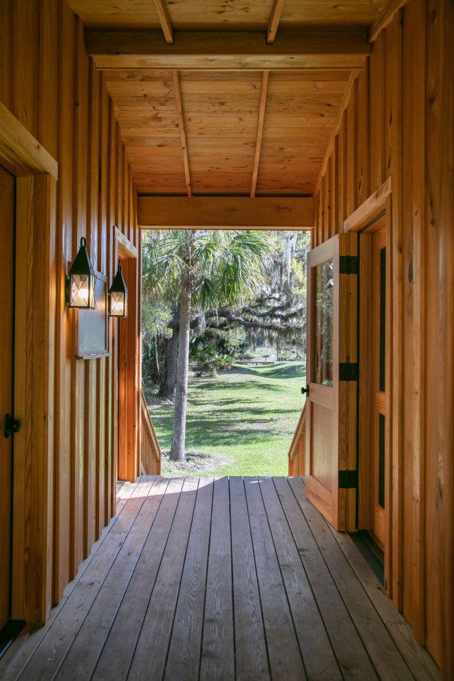 Aménagement d'un couloir campagne en bois de taille moyenne avec un mur marron, un sol en bois brun, un sol marron et poutres apparentes.