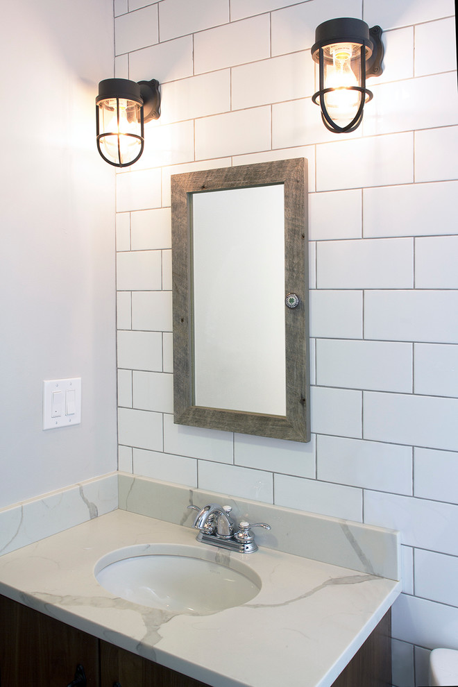 Inspiration for a mid-sized modern master bathroom in New York with flat-panel cabinets, dark wood cabinets, an alcove tub, a shower/bathtub combo, a two-piece toilet, white tile, subway tile, white walls, cement tiles, an undermount sink, engineered quartz benchtops, grey floor and a shower curtain.