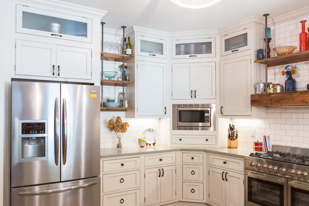 Design ideas for a mid-sized country u-shaped eat-in kitchen in St Louis with a farmhouse sink, beaded inset cabinets, white cabinets, quartzite benchtops, white splashback, subway tile splashback, stainless steel appliances, ceramic floors and a peninsula.