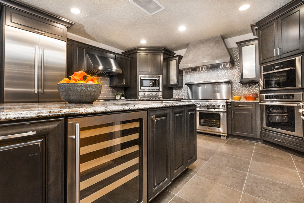 Large transitional u-shaped porcelain tile eat-in kitchen photo in Albuquerque with granite countertops, glass tile backsplash, stainless steel appliances, an island, recessed-panel cabinets, black cabinets and gray backsplash