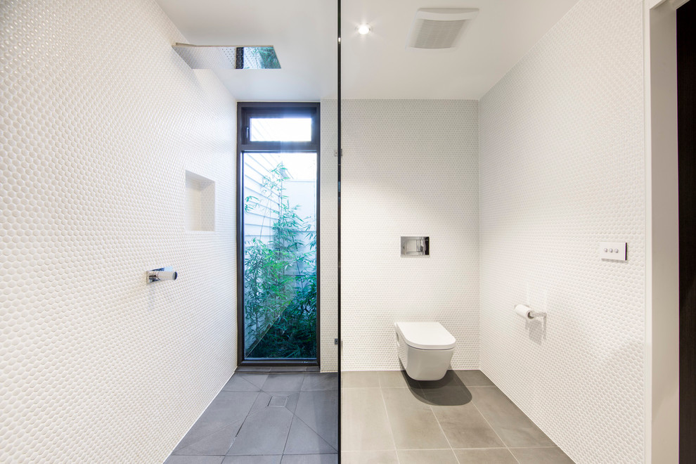 Inspiration for a mid-sized modern 3/4 bathroom in Melbourne with a curbless shower, a wall-mount toilet, white walls and slate floors.