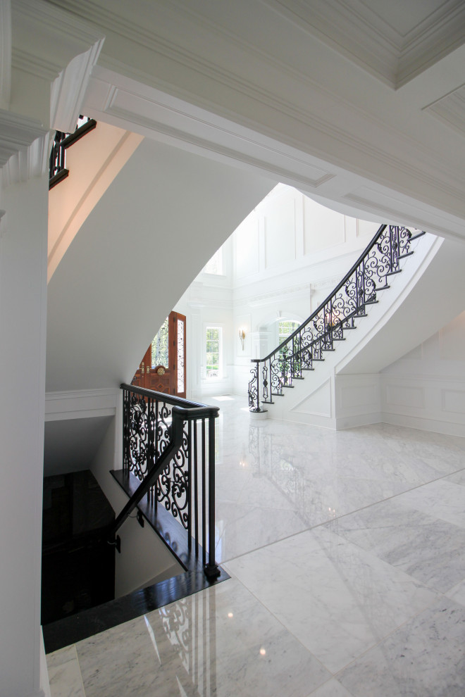 Inspiration for an expansive classic wood curved mixed railing staircase in DC Metro with wood risers and wainscoting.