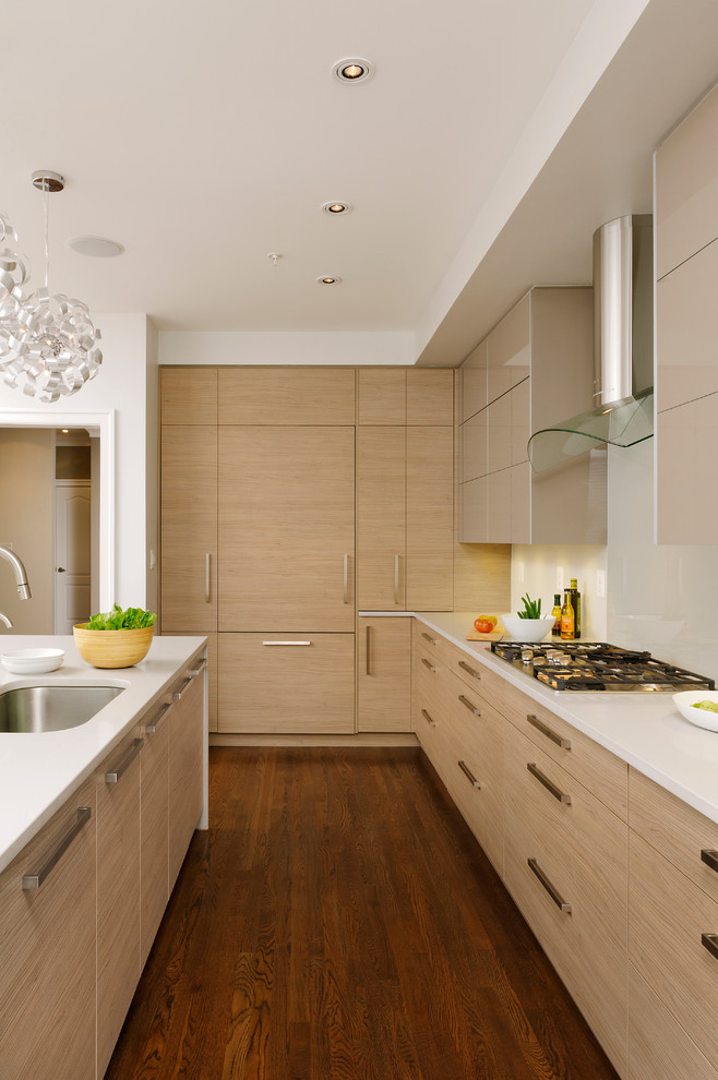 Inspiration for a mid-sized contemporary l-shaped eat-in kitchen in DC Metro with an undermount sink, flat-panel cabinets, light wood cabinets, quartzite benchtops, white splashback, glass sheet splashback, panelled appliances, medium hardwood floors and with island.