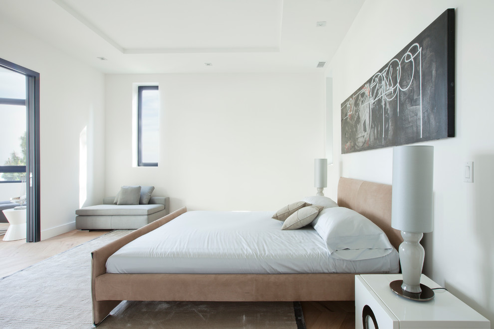 Photo of a large contemporary guest bedroom in Los Angeles with white walls and light hardwood floors.