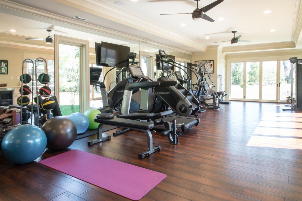This is an example of a mid-sized traditional home weight room in St Louis with beige walls and medium hardwood floors.