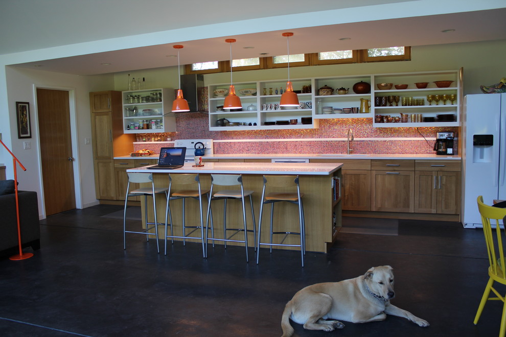 This is an example of a mid-sized eclectic galley eat-in kitchen in Chicago with an undermount sink, shaker cabinets, medium wood cabinets, quartz benchtops, orange splashback, mosaic tile splashback, white appliances, concrete floors, with island and black floor.