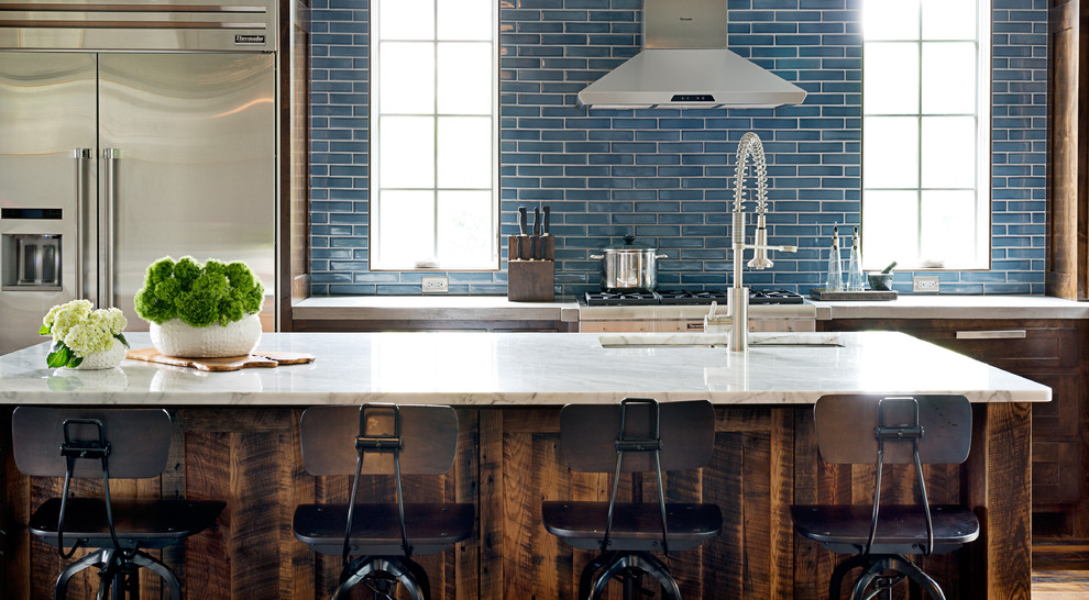Large transitional u-shaped dark wood floor kitchen photo with an undermount sink, shaker cabinets, dark wood cabinets, marble countertops, blue backsplash, subway tile backsplash, stainless steel appliances and an island