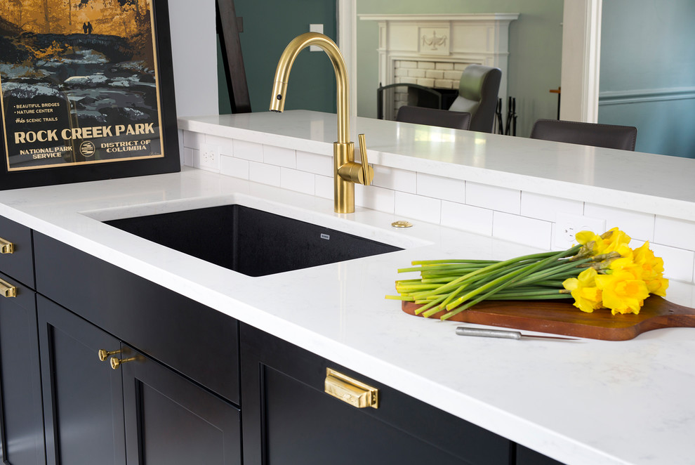Example of a mid-sized transitional black floor eat-in kitchen design in DC Metro with black cabinets, white backsplash, subway tile backsplash and stainless steel appliances
