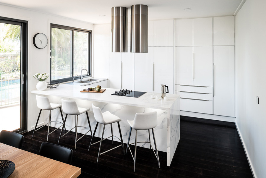 Design ideas for a mid-sized modern u-shaped eat-in kitchen in Melbourne with an integrated sink, flat-panel cabinets, white cabinets, quartz benchtops, black appliances, dark hardwood floors, a peninsula, black floor and yellow benchtop.