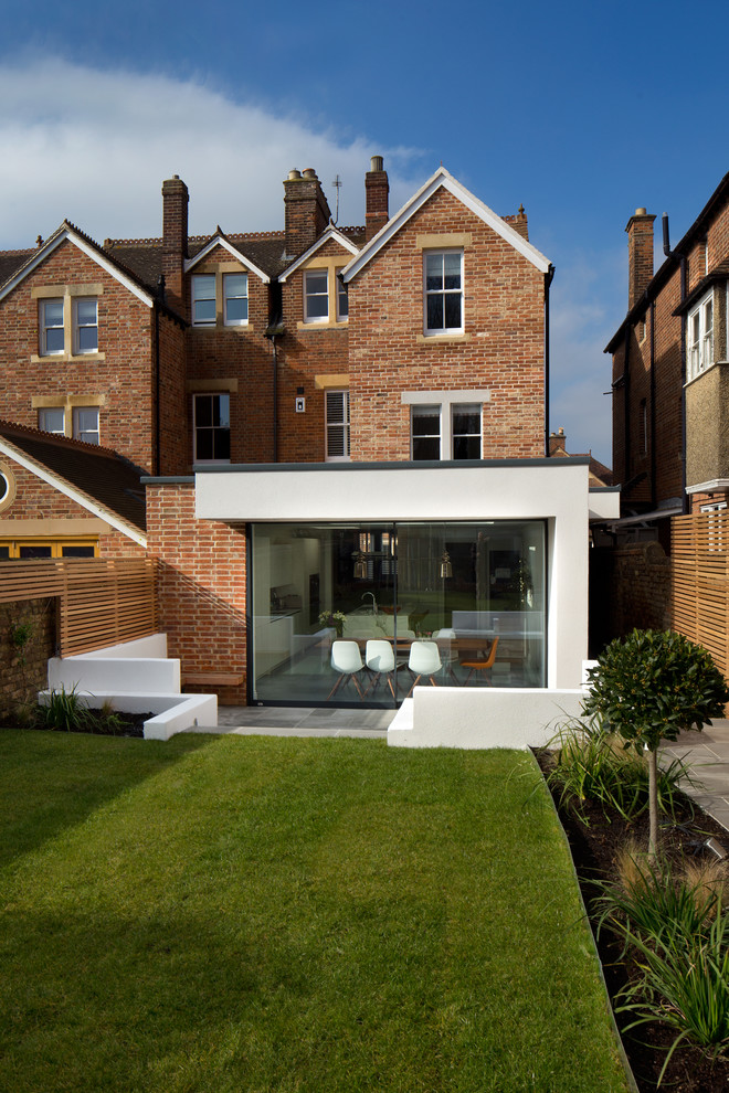 Photo of a mid-sized contemporary three-storey stucco white exterior in Oxfordshire with a gable roof.