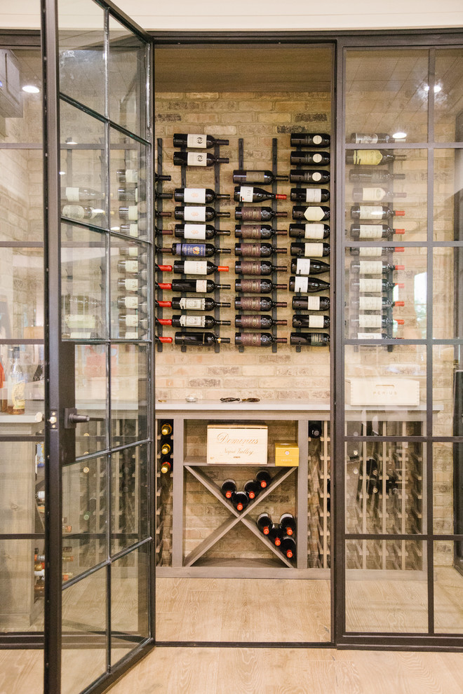 This is an example of a mid-sized transitional wine cellar in Atlanta with light hardwood floors, storage racks and brown floor.