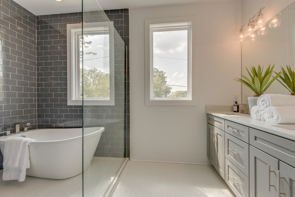 Large traditional master wet room bathroom in Nashville with a freestanding tub, gray tile, white walls, an undermount sink, engineered quartz benchtops, white floor and a hinged shower door.