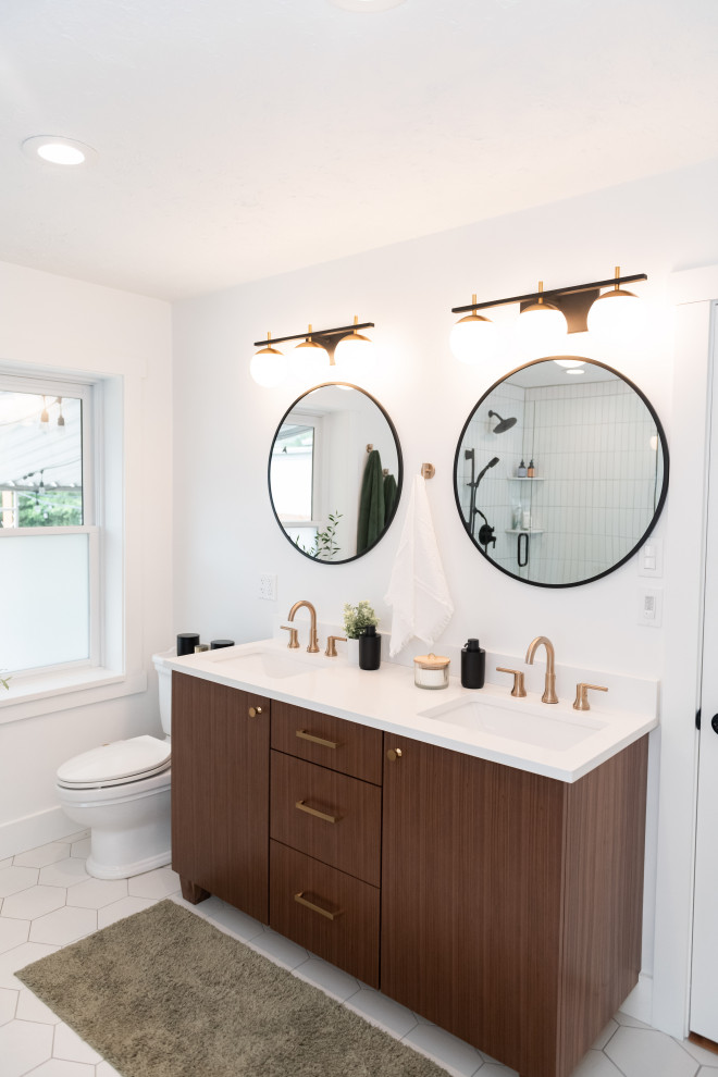 This is an example of a large midcentury master bathroom in Salt Lake City with flat-panel cabinets, medium wood cabinets, a freestanding tub, a corner shower, white tile, ceramic tile, white walls, porcelain floors, an undermount sink, engineered quartz benchtops, white floor, a hinged shower door, white benchtops, a shower seat, a double vanity and a built-in vanity.
