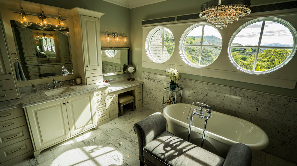 Design ideas for a mid-sized transitional master bathroom in Salt Lake City with raised-panel cabinets, white cabinets, a freestanding tub, black tile, gray tile, white tile, marble, beige walls, marble floors, an undermount sink, marble benchtops and white floor.