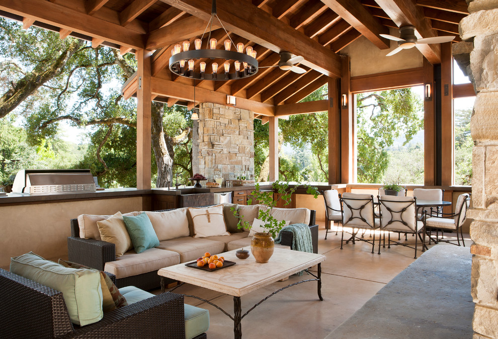 This is an example of a large mediterranean backyard patio in San Francisco with a fire feature and a roof extension.