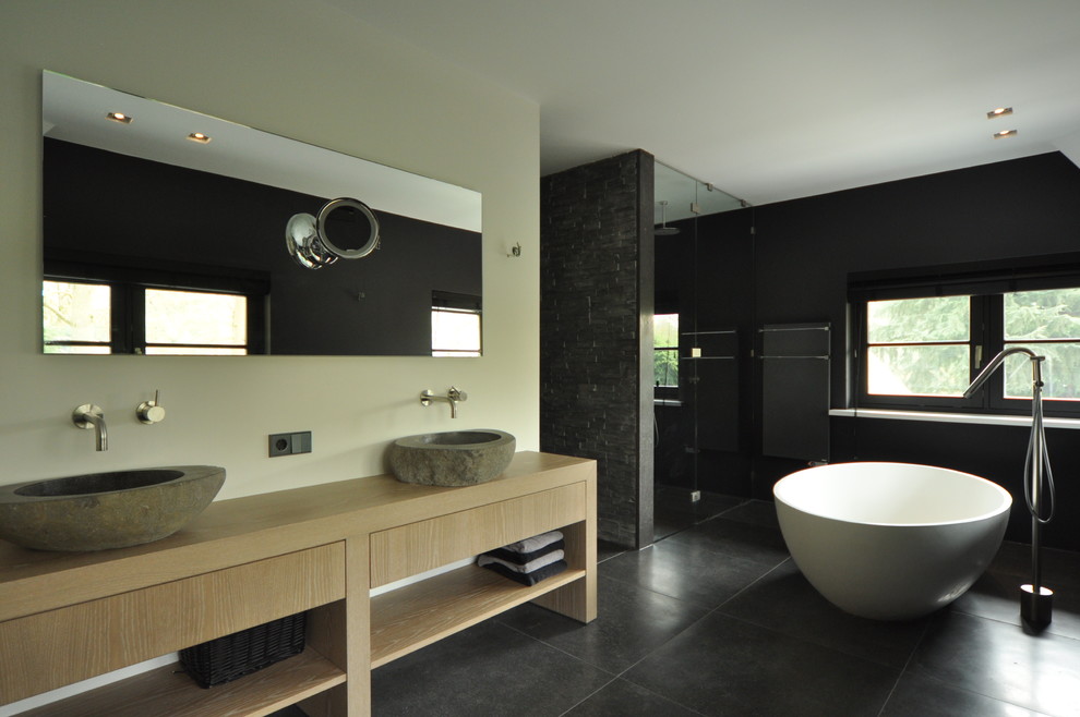 Photo of a contemporary bathroom in Amsterdam with a freestanding tub and an open shower.
