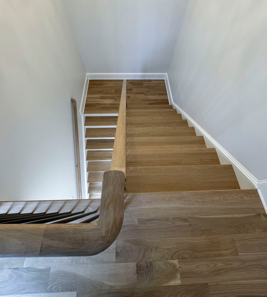 Пример оригинального дизайна: большая лестница на больцах в классическом стиле с деревянными ступенями, крашенными деревянными подступенками и перилами из смешанных материалов