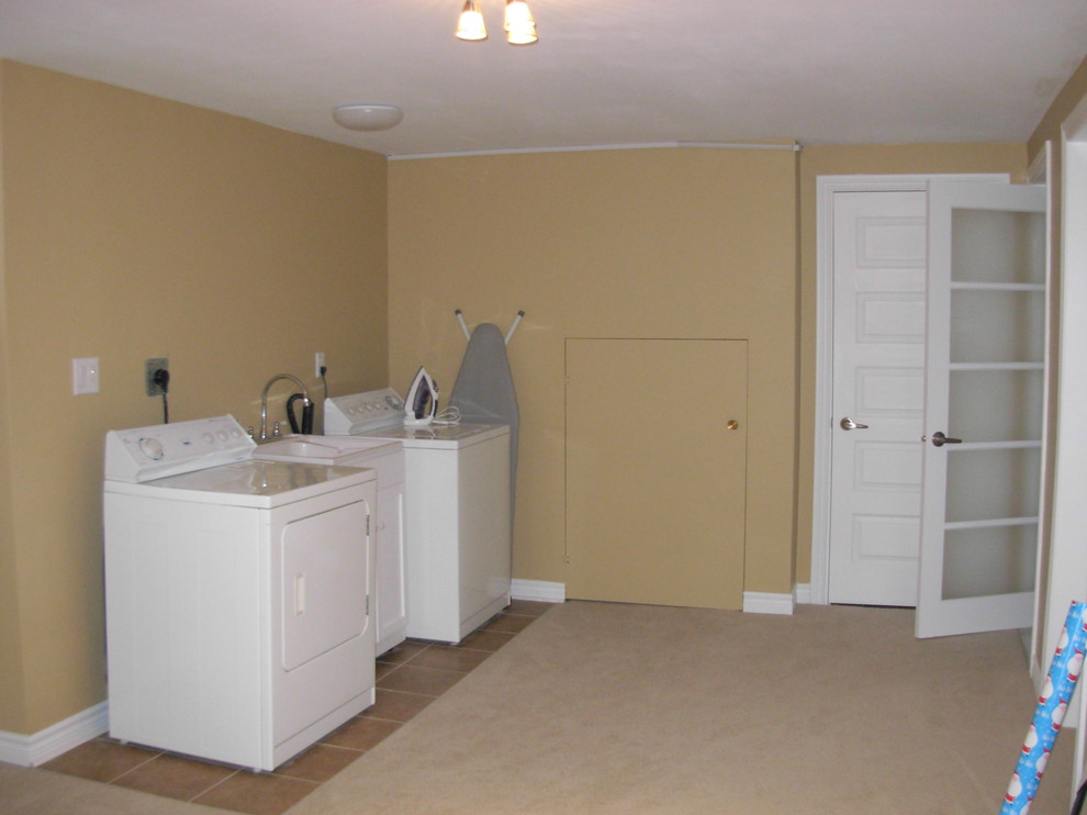 This is an example of a mid-sized traditional dedicated laundry room in Toronto with an utility sink, beige walls, ceramic floors and a side-by-side washer and dryer.