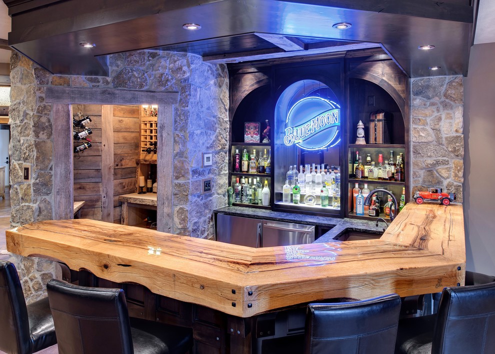 Photo of a country u-shaped seated home bar in Minneapolis with an undermount sink, wood benchtops, dark wood cabinets, concrete floors and beige benchtop.