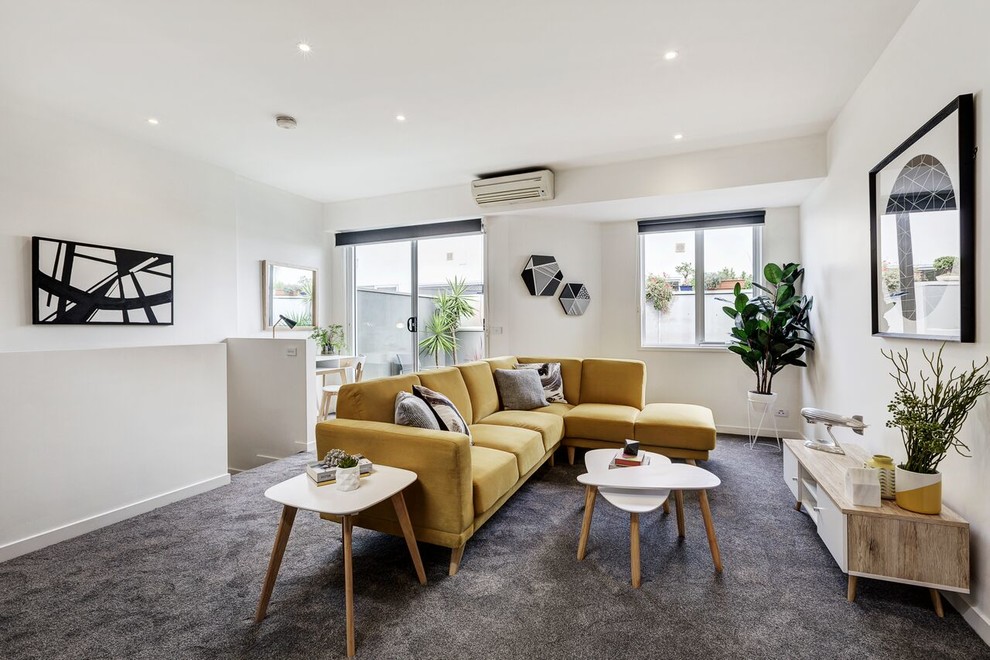 Transitional living room in Melbourne with white walls, carpet and grey floor.
