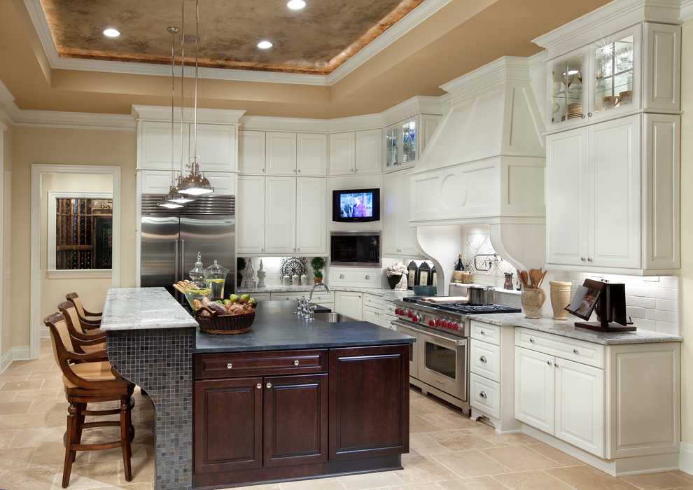 Inspiration for a timeless l-shaped kitchen remodel in Columbus with a farmhouse sink, raised-panel cabinets, white cabinets, white backsplash, subway tile backsplash and stainless steel appliances