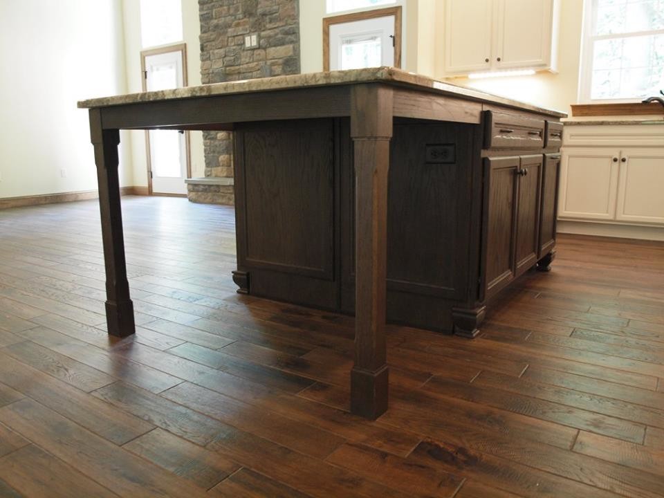 Example of a mid-sized mountain style l-shaped dark wood floor and brown floor open concept kitchen design with a single-bowl sink, recessed-panel cabinets, beige cabinets, granite countertops, stainless steel appliances, an island and brown countertops