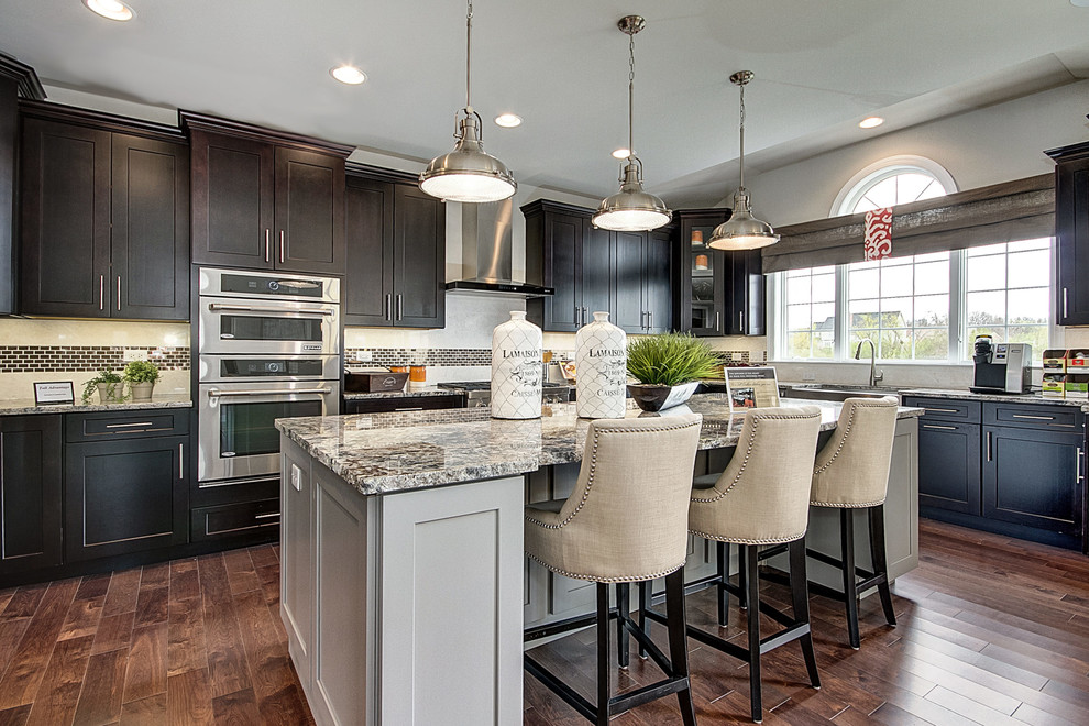Transitional l-shaped kitchen in Chicago with shaker cabinets, dark wood cabinets, black splashback, stainless steel appliances, medium hardwood floors and with island.