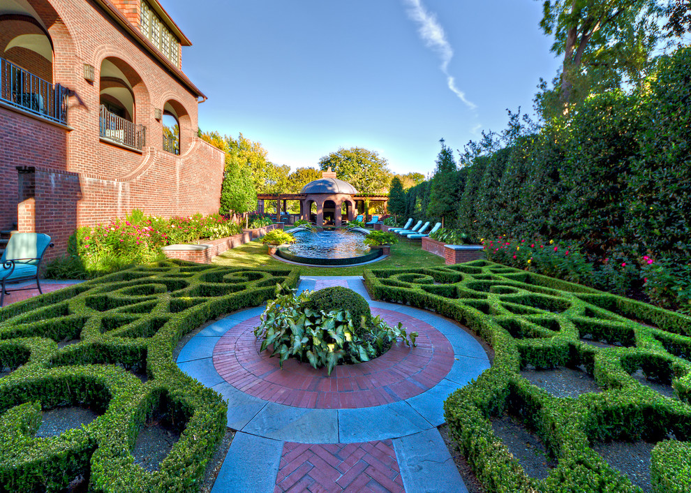 This is an example of an expansive traditional formal garden in Dallas with brick pavers.