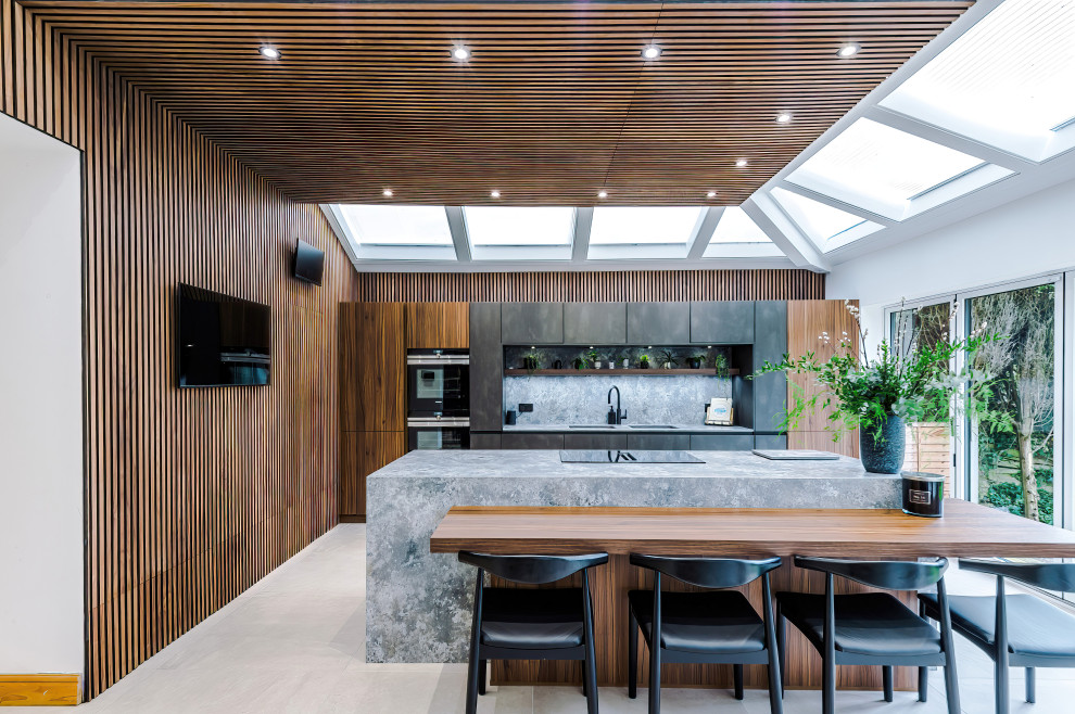 Cette image montre une grande cuisine ouverte design en bois brun avec un évier intégré, un plan de travail en quartz, un électroménager en acier inoxydable, 2 îlots et un plafond en bois.