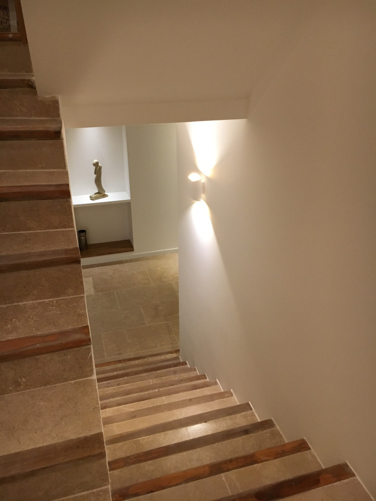 Photo of a mid-sized contemporary limestone u-shaped staircase in Other with limestone risers.