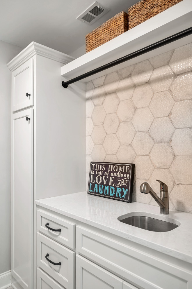 Design ideas for a laundry room in Nashville with an utility sink, shaker cabinets, white cabinets, quartz benchtops, beige splashback, ceramic splashback, grey walls, a side-by-side washer and dryer and white benchtop.