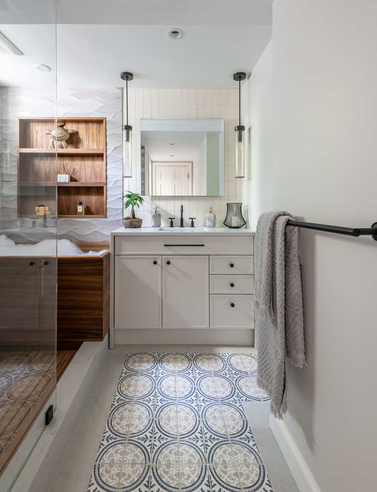 This is an example of a beach style 3/4 bathroom in DC Metro with recessed-panel cabinets, beige cabinets, a japanese tub, an open shower, beige tile, white walls, an undermount sink, multi-coloured floor, an open shower and white benchtops.