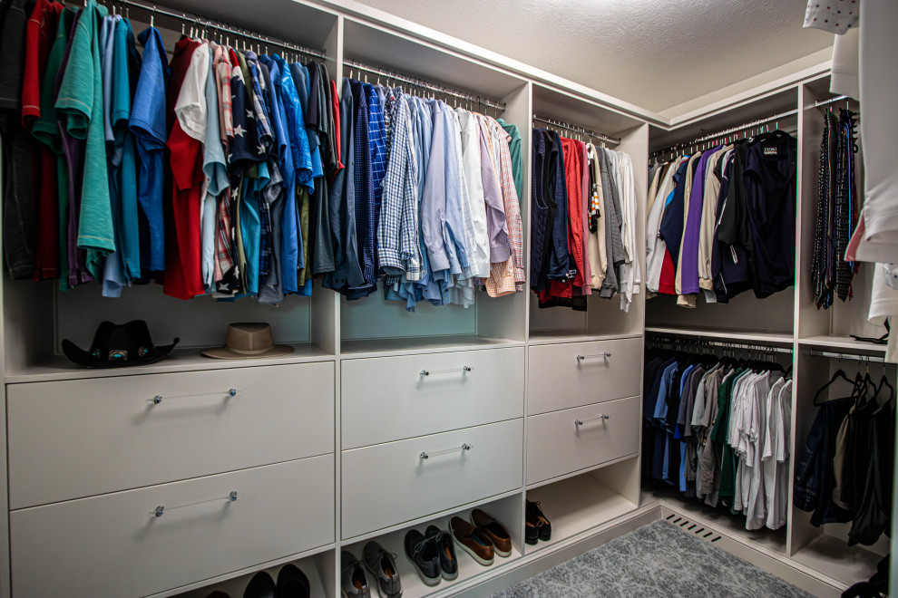 This is an example of a mid-sized transitional men's walk-in wardrobe in Cleveland with flat-panel cabinets, white cabinets, carpet and grey floor.