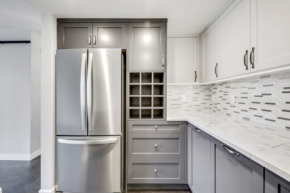 This is an example of a small transitional u-shaped separate kitchen in Calgary with a drop-in sink, shaker cabinets, white cabinets, quartzite benchtops, metallic splashback, mosaic tile splashback, stainless steel appliances, cork floors, no island, brown floor and white benchtop.