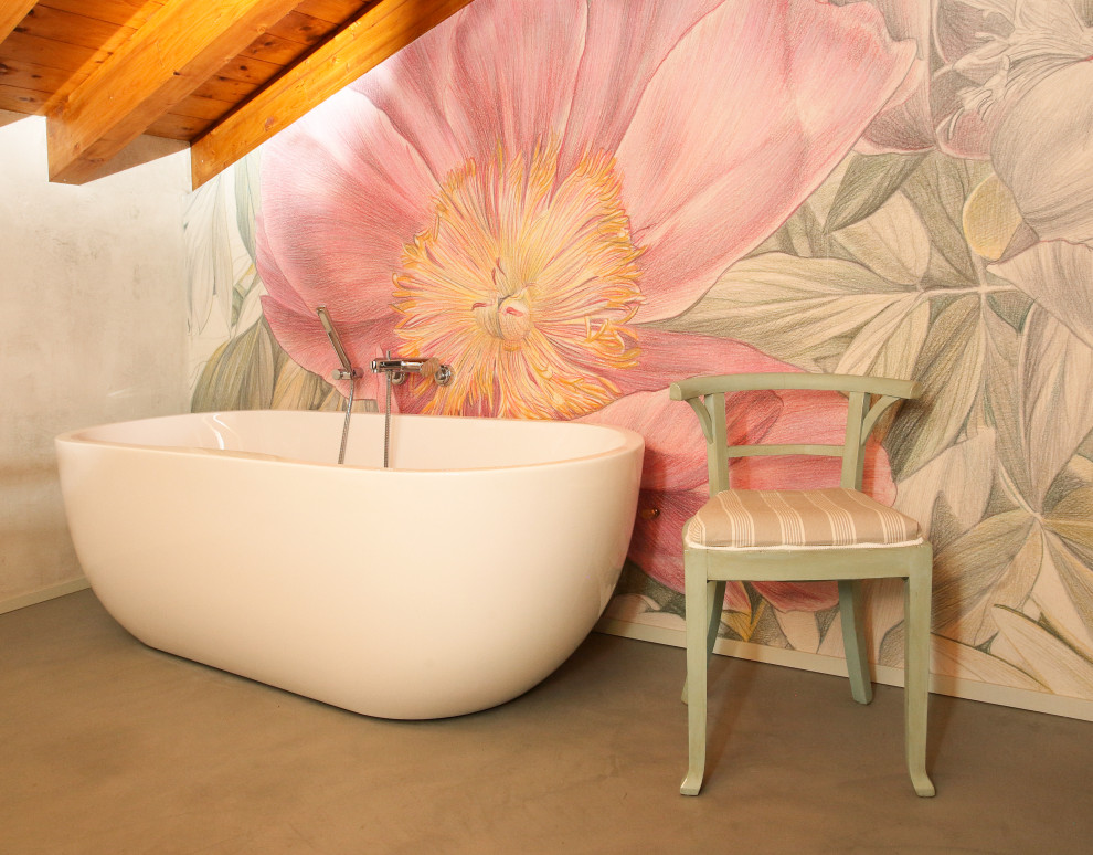 Example of a mid-sized trendy master gray floor, exposed beam and wallpaper freestanding bathtub design in Milan with a one-piece toilet and pink walls