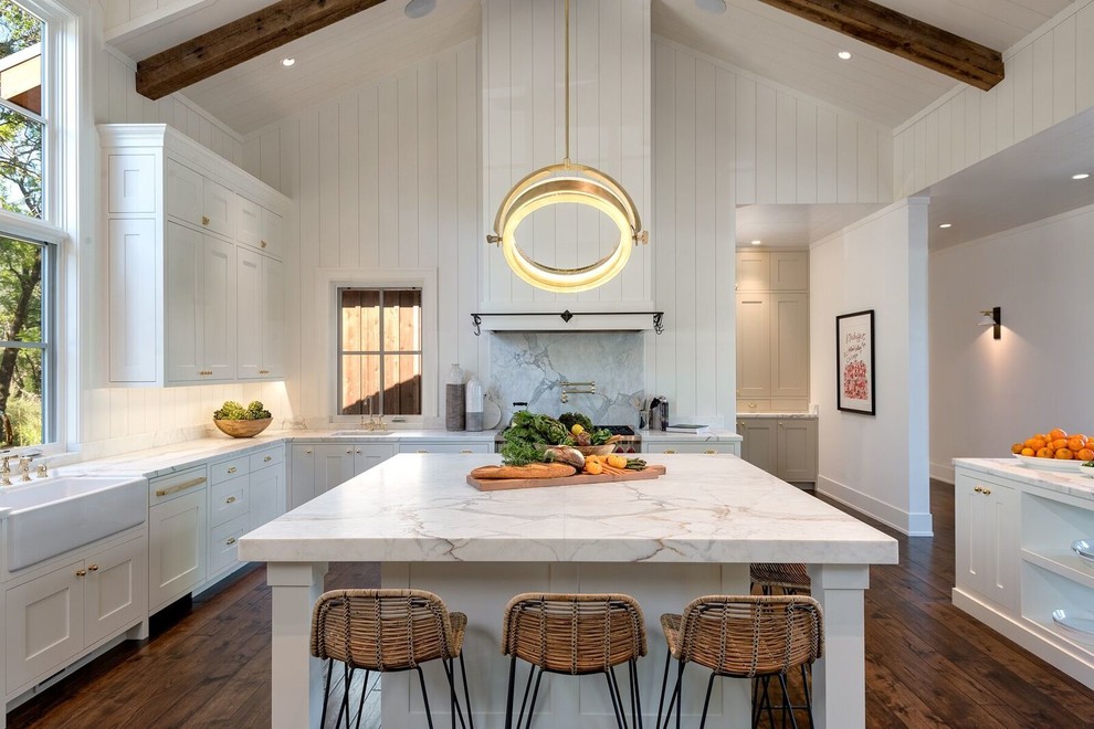 Design ideas for an expansive country u-shaped open plan kitchen in San Francisco with a farmhouse sink, white cabinets, dark hardwood floors, with island, brown floor, marble benchtops, grey splashback, marble splashback, multi-coloured benchtop, panelled appliances and shaker cabinets.