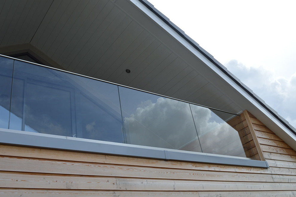 Diseño de fachada de casa multicolor y gris escandinava de tamaño medio de dos plantas con revestimiento de madera, tejado a dos aguas, tejado de teja de barro y panel y listón