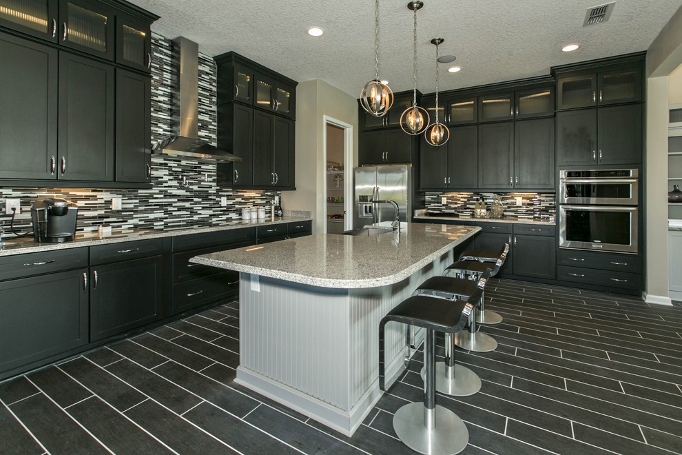 Photo of a large modern galley eat-in kitchen in Jacksonville with a farmhouse sink, flat-panel cabinets, black cabinets, granite benchtops, multi-coloured splashback, matchstick tile splashback, stainless steel appliances, ceramic floors and with island.