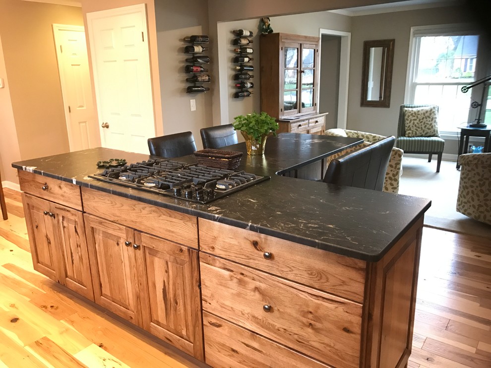 Inspiration for a mid-sized rustic l-shaped eat-in kitchen remodel with an undermount sink, raised-panel cabinets, medium tone wood cabinets, granite countertops and an island
