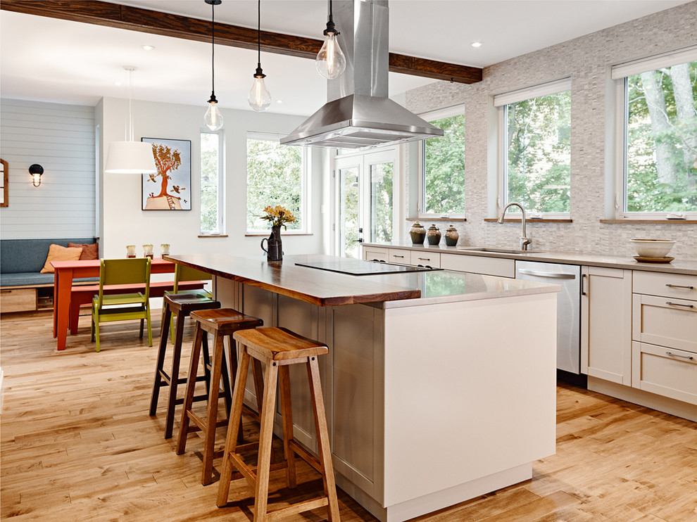 Large transitional l-shaped medium tone wood floor eat-in kitchen photo with an undermount sink, shaker cabinets, medium tone wood cabinets, quartz countertops, gray backsplash, mosaic tile backsplash, stainless steel appliances and an island