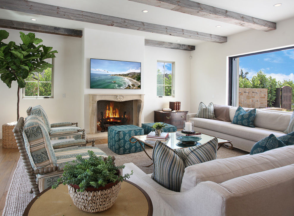 Inspiration for a mid-sized mediterranean family room in Orange County with white walls, a standard fireplace and a wall-mounted tv.