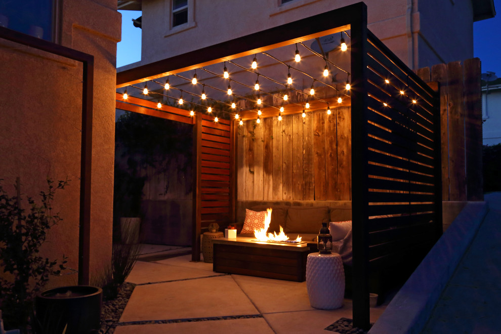 Photo of a small modern courtyard patio in San Luis Obispo with a fire feature, concrete slab and a pergola.