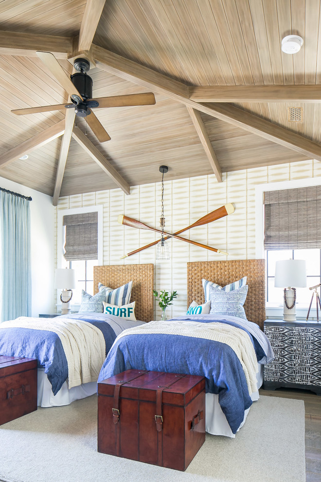 Photo of a large tropical guest bedroom in Orange County with medium hardwood floors, beige walls and brown floor.
