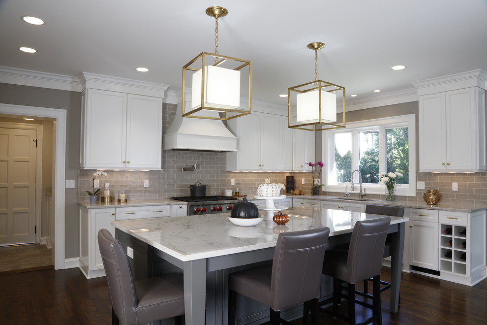 Design ideas for a large transitional l-shaped eat-in kitchen in Cleveland with an undermount sink, white cabinets, quartzite benchtops, porcelain splashback, stainless steel appliances, dark hardwood floors, with island, brown floor, white benchtop, grey splashback and shaker cabinets.